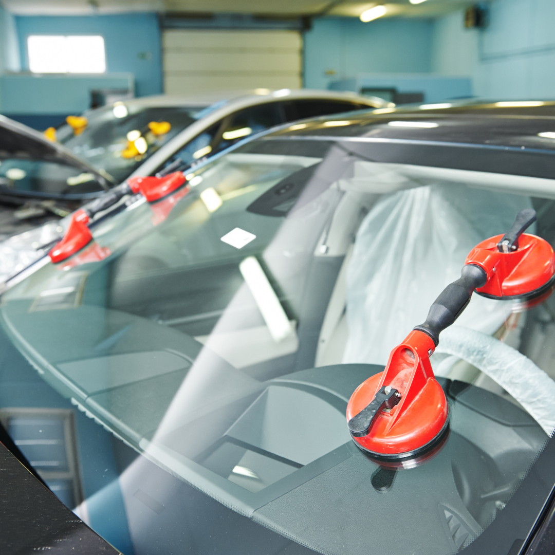 Car Windshield Cracks secured with suction cups in a workshop.